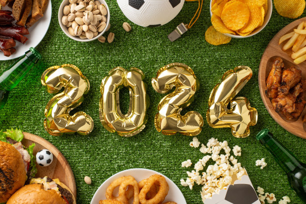 2024年欧洲杯足球赛观看装置。俯瞰2024形状的气球，派对零食，如薯片，坚果，炸鸡，洋葱圈，爆米花，薯片，啤酒瓶，足球，裁判在草地上的哨子图片下载