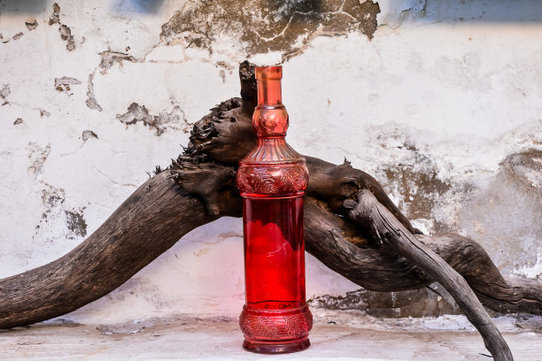 一根圆木上放着一瓶红色液体图片下载