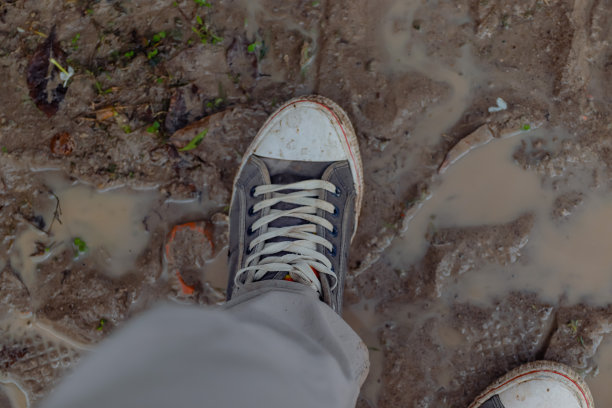 脏鞋暴露在湿土上图片下载