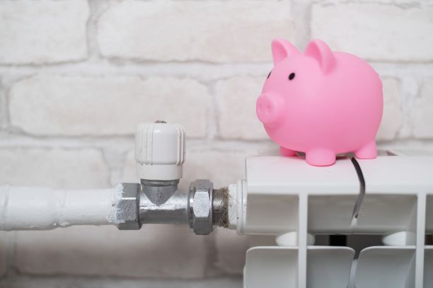 砖墙背景上暖气片上的储钱罐图片下载