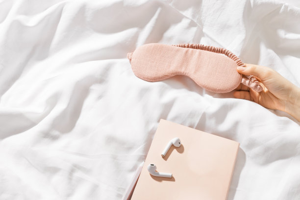 女人手拿粉红眼罩，靠近耳机，笔记本或愿望日记躺在床上，俯视图最小的生活方式照片，复制空间，增加正念，良好的睡眠，家庭放松图片下载