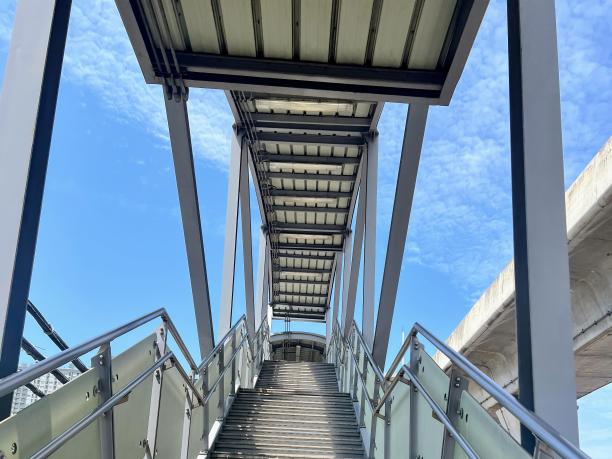 一幅以天空为背景的通往桥梁的楼梯的照片。图片下载