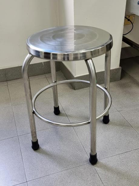 一张铺着瓷砖的地板上有一个玻璃顶的金属凳子的照片。图片下载