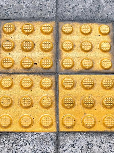 一张带有四个正方形黄点的黄色瓷砖的照片。图片下载