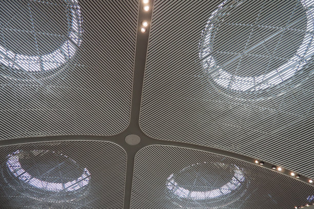 伊斯坦布尔机场天花板采用圆形抽象灯具，优雅精致。现代时尚的大型建筑、大厅设计，营造出宽敞、大气的感觉。灰白色的盘子图片下载