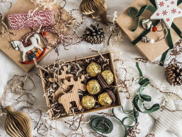 圣诞可食用礼物-圣诞装饰鹿和糖果在一个工艺盒。圣诞装饰，盒子，彩带，玩具在浅色背景上。圣诞节的概念图片下载