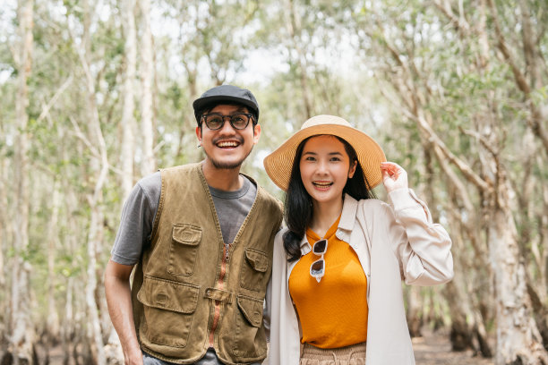 快乐的亚洲夫妇在森林里旅行。快乐的男人和女人周末旅行，假期时间在大自然中散步，花时间享受假期图片下载