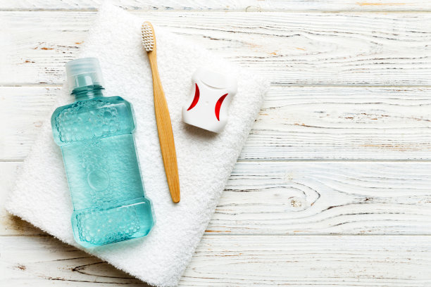 漱口水和其他口腔卫生产品在彩色桌面视图与复制空间。平的。口腔卫生。口腔护理产品和空间的文字在浅色背景。概念图片下载