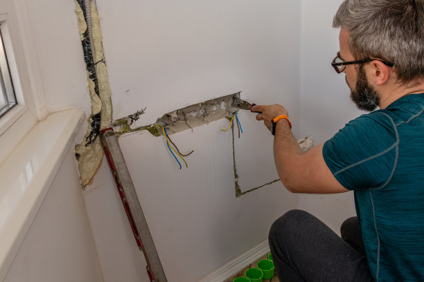 一个人把墙上的插座装在石膏上图片下载