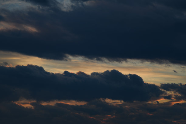 黑暗的夜空。坏天气。蓬松的云彩。光线穿透云层。通用水平照片。背景图片。图片下载