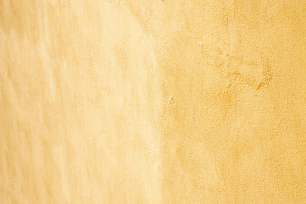 淡黄色膏状墙面灰泥。背景图片。混凝土表面泛着浅色。壁纸纹理图片。前视图。图片下载