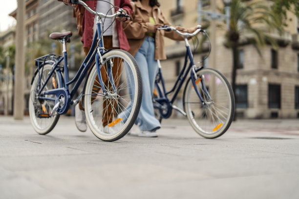 朋友们推着自行车走在街上的照片。图片下载
