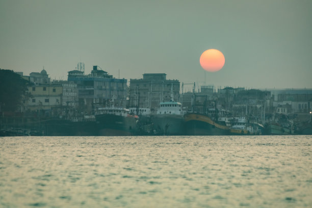 日落时分，吉大港的船只在水面上图片下载