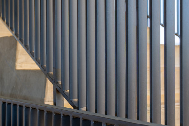 一个现代灰色金属栏杆和楼层之间的混凝土楼梯的特写照片。图片下载