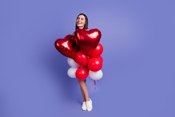 全尺寸照片，漂亮的年轻女子拿着气球笑空空间孤立的紫色背景图片下载