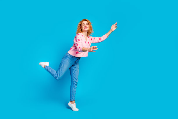 迷人的年轻女子的全身照片伸展双手想拥抱穿着时尚的粉红色衣服孤立的蓝色背景图片下载