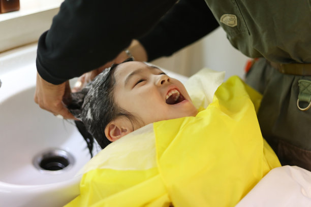 一个女孩在洗发水摊洗头图片下载