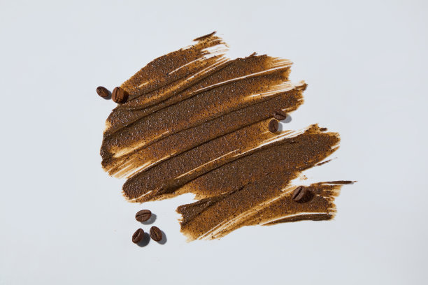 条纹棕色的去角质霜站在白色的背景与一些咖啡豆装饰，照片为广告去角质产品由咖啡成分。俯视图，复制空间图片下载