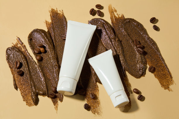 制作去角质磨砂膏的咖啡成分的创意照片，两个白色的化妆品容器样品平放在深棕色磨砂膏纹理上。俯视图照片，复制空间图片下载