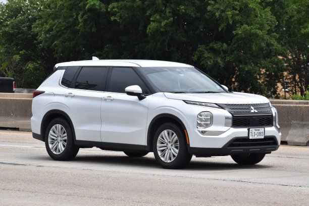 一辆三菱欧蓝德越野车在自然保护区附近巡航。图片下载