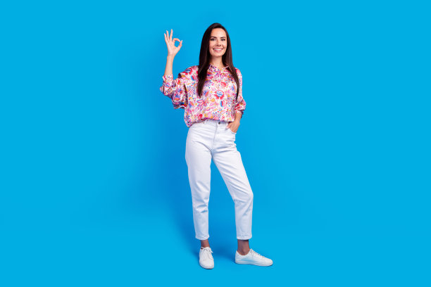 照片的可爱的积极的女士穿着印花衬衫显示ok标志空的空间孤立的蓝色背景图片下载