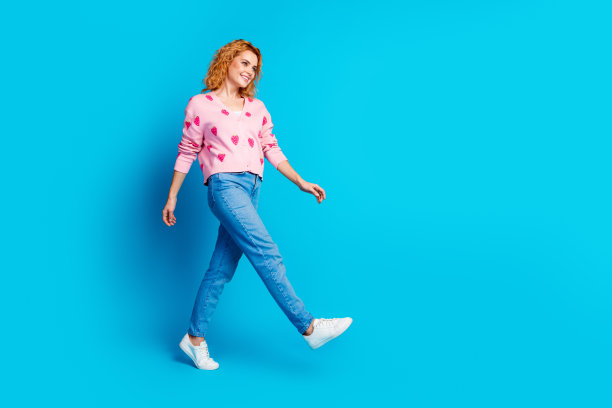 可爱的年轻女士在黑色星期五穿着时髦的粉红色衣服，在蓝色背景上孤立的全身照片图片下载