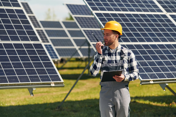 使用对讲机进行通信。白天在户外使用光伏太阳能电池板的工程师图片下载