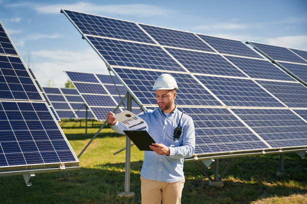 晴朗的白天。工程师在户外使用光伏太阳能电池板图片下载
