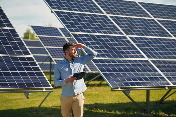 拿着笔记本电脑。白天在户外使用光伏太阳能电池板的工程师图片下载