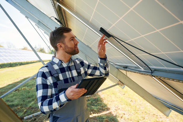 下有光伏太阳能板和带数码平板。白天户外工程师图片下载