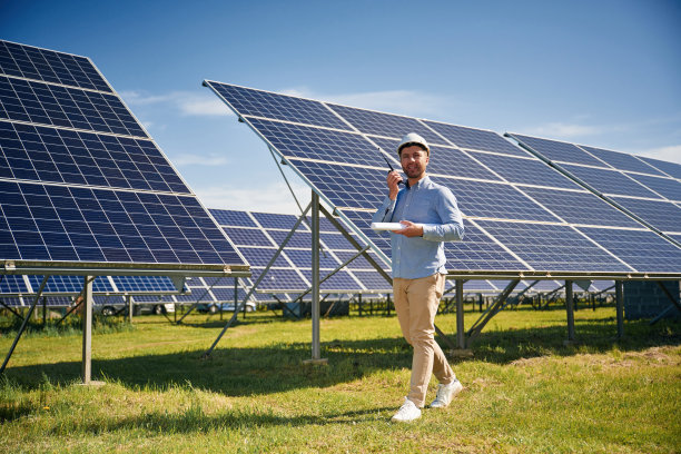 穿着正装。白天在户外使用光伏太阳能电池板的工程师图片下载