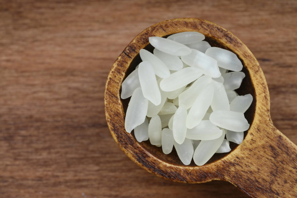 木质背景上的白色长米特写，未煮熟的生谷物，宏观。图片下载