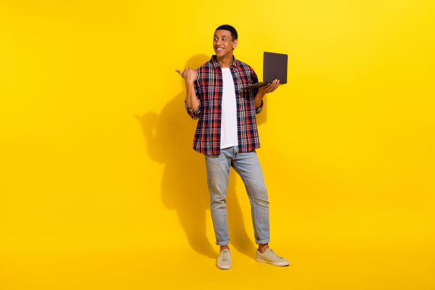 智能男子穿格子衬衫牛仔裤的全长照片手臂在口袋里拿智能手机孤立在生动的色彩背景图片下载