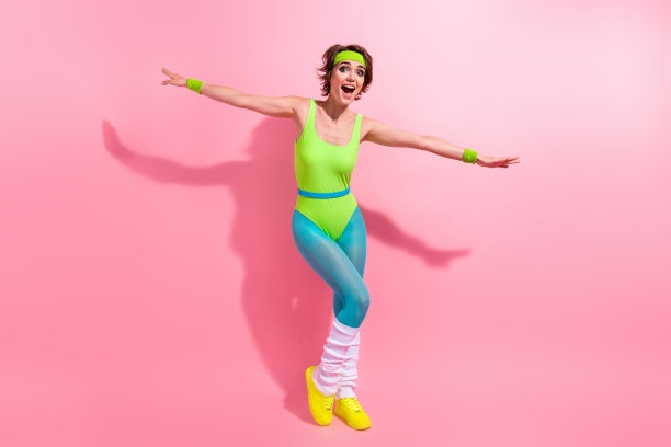 全身照片的运动喜出望外的健身教练舞蹈的双手翅膀孤立在粉红色的背景图片下载