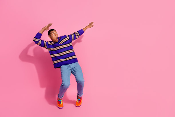 全长照片正面印象深刻的男人穿条纹毛衣跳舞迪斯科舞厅看起来空的空间孤立的粉红色背景图片下载