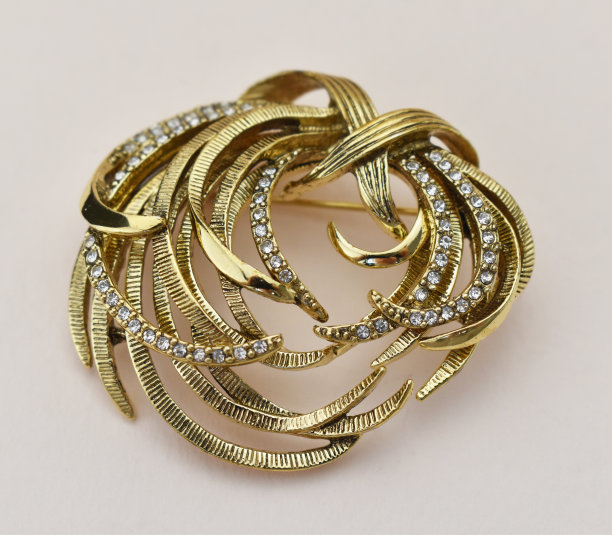黄金复古胸针与水钻米色的背景，强调复古的珠宝为妇女，宣传照片为网上珠宝店图片下载
