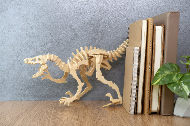 桌上有笔记本和木恐龙。办公桌空间图片下载