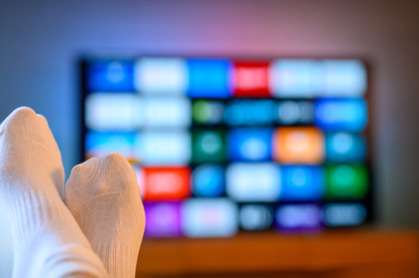 一个孤独的人坐在电视机前为晚上选了一部电影图片下载