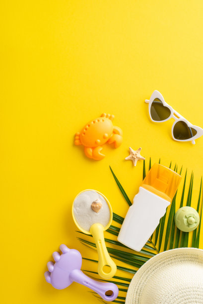 明亮而有趣的夏季垂直排列，以海滩玩具，太阳镜和黄色背景上的帽子为特色，非常适合夏季和假期图片下载