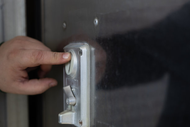 一只手把一枚硬币放进洗车机里。一个男人把一枚硬币放进洗衣机洗车的特写镜头。那人自己付了车的钱。图片下载