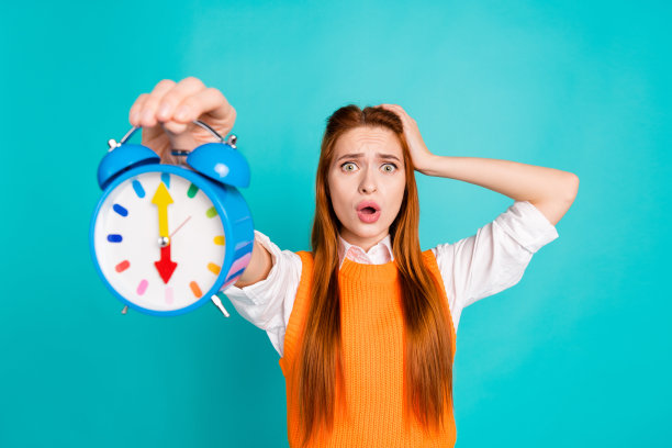 照片中，压力大、情绪低落的女人穿着时髦的橙色衣服，声音响，闹钟响，想念工作，孤立在青色的背景上图片下载