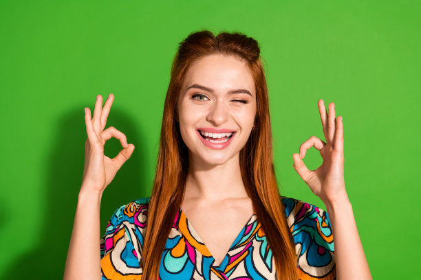 照片肖像迷人的年轻女子显示好的质量眨眼穿着时尚复古的衣服孤立的绿色背景图片下载