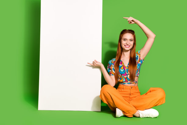 漂亮的年轻女子的全尺寸照片直接手指空的空间屏幕穿顶隔离在明亮的绿色背景图片下载