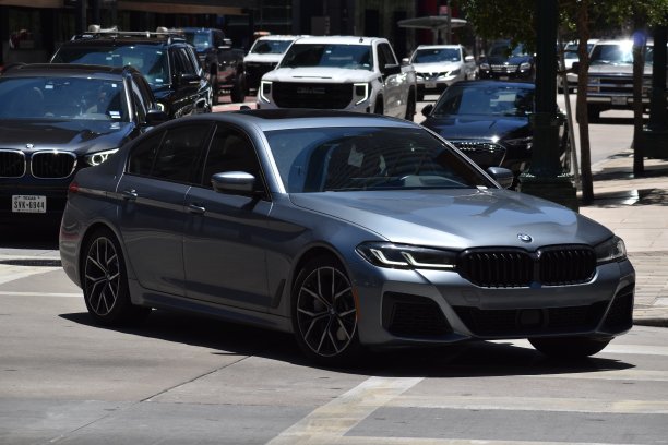 一辆灰色的宝马5系豪华轿车在市区巡游图片下载