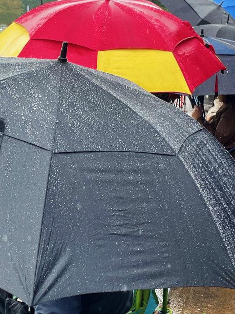 美国弗吉尼亚州伯克，父母在下雨天观看足球比赛图片下载