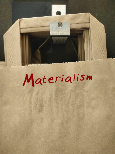 纸购物袋上写着物质主义——相信拥有金钱、财产和身体舒适是最重要的，以自我为中心的社会图片下载