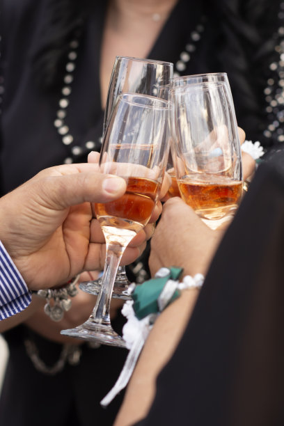 手捧满香槟的酒杯，与欢乐派对的叮当声相连图片下载