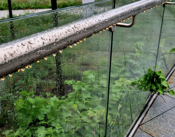 手柄底部是一个带黄色灯的嵌入式LED灯条。楼梯栏杆的侧面由无框架的胶合玻璃板制成。金属把手上的不锈钢栏杆图片下载