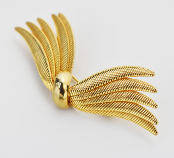 米色背景上的金蝴蝶结复古胸针，强调女性复古珠宝，网上珠宝店的宣传照片图片下载