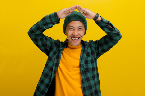 快乐的亚洲男子在头顶做手势，象征着屋顶或家图片下载